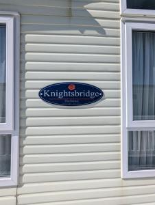 a blue sign on the side of a house at Unobstructed Sea Views , Rockley Park , Poole in Lytchett Minster