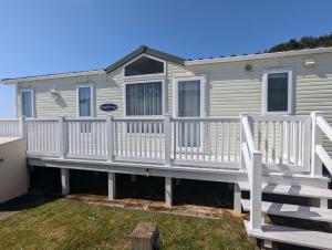 a mobile home with a white deck and railing at Unobstructed Sea Views , Rockley Park , Poole in Lytchett Minster