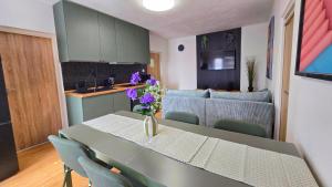 a kitchen and living room with a table with purple flowers at Urban Zen Stay in Banská Bystrica