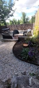 a patio with couches and flowers in a yard at Troglo entre Caves et Châteaux in Montlouis-sur-Loire