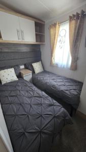 a bedroom with two beds and a window at Coopers Corner - Stylish 2 bedroom home, Seal Bay - Pets Welcome in Selsey +19 photos