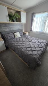 a large bed in a bedroom with a large window at Coopers Corner - Stylish 2 bedroom home, Seal Bay - Pets Welcome in Selsey