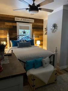 ein Schlafzimmer mit einem großen Bett und einem Deckenventilator in der Unterkunft Mile 77 Cottages Lakefront 100yr old Railway Cottage in Youbou