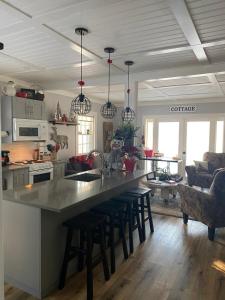 eine Küche mit einer großen Theke mit Hockern darin in der Unterkunft Mile 77 Cottages Lakefront 100yr old Railway Cottage in Youbou