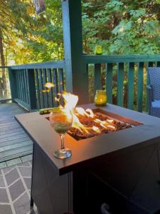 eine Feuerstelle auf einem Tisch auf einer Terrasse in der Unterkunft Mile 77 Cottages Lakefront 100yr old Railway Cottage in Youbou