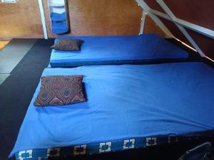 two beds in a room with blue sheets and pillows at Cabaña Vista Pinares San Ignacio Chalatenango in Chalatenango +33 photos