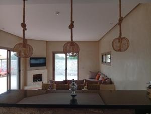 a living room with a couch and three hanging lights at Villa Khadija in Sidi Kaouki