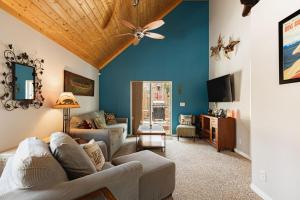een woonkamer met blauwe muren en een plafond bij Blissful Bay Cabin in Big Bear Lake