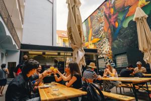 a group of people sitting at tables in a restaurant at Drunken Monkey Hostel in Prague