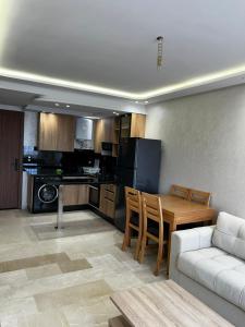 a kitchen and living room with a table and a couch at Nouvel Appartement Parc Mohammedia in Mohammedia