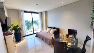 Una sala de estar con una cama y una mesa de cristal. en Modern apartment with pool, near Costanera beach, en Encarnación