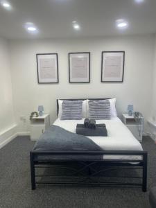 ein Schlafzimmer mit einem Bett mit drei Bildern an der Wand in der Unterkunft 4 Bed Family & Work Ready Home in Ponders End