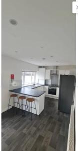 eine Küche mit einem Tisch und 2 Hockern in der Unterkunft 4 Bed Family & Work Ready Home in Ponders End