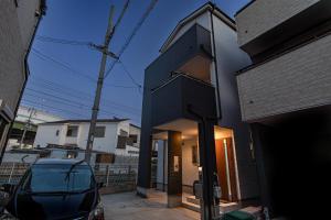 大阪市にあるOYADO - Self Check-In Onlyの車が目の前に停まった黒い家