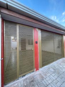 un garage avec des portes roulantes sur le côté d'un bâtiment dans l'établissement Casa Privativa com Quarto Confortável e Cozinha Ótima Localização em Foz do Iguaçu, à Foz do Iguaçu 21 autres photos