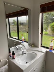 a bathroom with a sink and a large mirror at Parkhill Lodge Villa in Hastings +16 photos