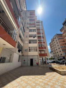 un grand immeuble d'appartements avec un escalier dans un parking dans l'établissement Çuka Apartment, à Pogradec