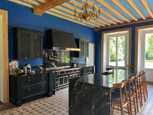 a kitchen with a black counter and blue walls at Le Château d'Elbeuf-en-Bray in Elbeuf-en-Bray