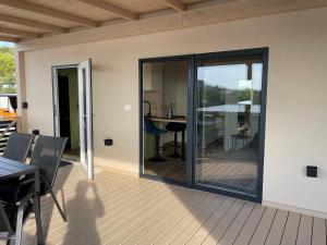 a balcony with sliding glass doors and a table and chairs at Sea House in Drage