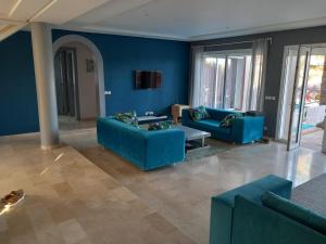 a living room with blue walls and blue couches at Chalet Mirleft in Mirleft