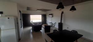 a living room with a table and a refrigerator at La paz in Médanos