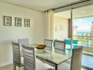 une salle à manger avec une table et des chaises en verre dans l'établissement Sweet Home at the Beach - Next to Beach Park, à Aquiraz