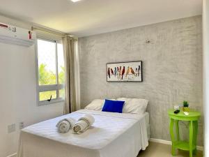 une chambre avec un lit blanc avec des serviettes dessus dans l'établissement Sweet Home at the Beach - Next to Beach Park, à Aquiraz 13 autres photos