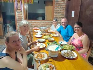 a group of people sitting around a table eating food at Riung Guesthouse in Riung