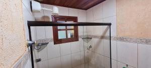a shower with a glass door in a bathroom at Ficar Bem Lumiar in Nova Friburgo +7 photos