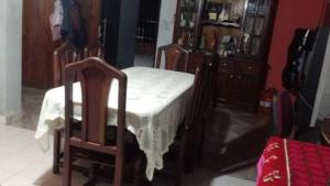 un comedor con mesa y sillas, mesa blanca y sillón en Como en Casa, en La Porteña