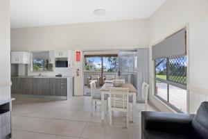a kitchen and dining room with a table and chairs at Reflections Nambucca Heads - Holiday Park in Nambucca Heads