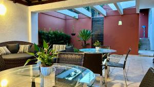 a patio with tables and chairs and a couch at Casa do Lago em Londrina in Londrina