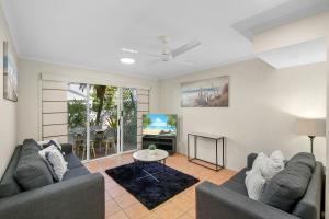 ein Wohnzimmer mit zwei Sofas und einem Fernseher in der Unterkunft Oaks Family Getaway - Resort, Beach in Golden Beach