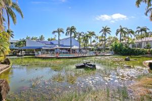 ein Teich mit Schildkröten im Wasser mit Palmen in der Unterkunft Oaks Family Getaway - Resort, Beach in Golden Beach