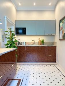 a kitchen with blue cabinets and a tiled floor at Maison Stefana Rynek in Rzeszów