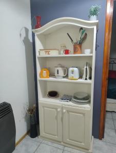 a white shelf with dishes and utensils on it at Shala Alquiler temporario in Río Grande +5 photos