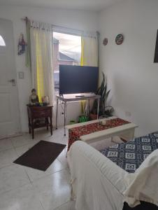 a living room with a tv and a couch and a table at Shala Alquiler temporario in Río Grande