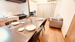 a dining room table with chairs and a kitchen at matsuokabase in Kitakyushu