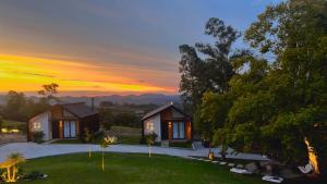 a house with a sunset in the background at Le Mont Chalés in Bento Gonçalves
