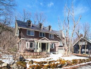 a brown house with snow on the ground at Echo Villa the Spacious in Hakuba