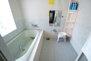 a bathroom with a tub and a toilet and a sink at Echo Villa the Spacious in Hakuba +11 photos