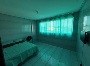 a bedroom with a bed and a large window at Apê 200 in Caruaru