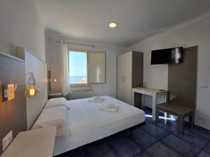 a bedroom with a large white bed and a desk at Residenza Calypso in Pizzo +8 photos