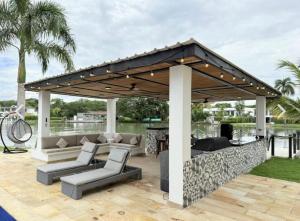 a pavilion with couches and chairs on a patio at Casa con piscina y BBQ en Lagos del Peñón Girardot in Girardot
