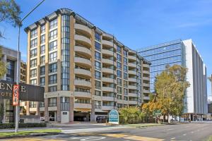 a large building on a city street with a street at Stylish Braddon Retreat 2Bedroom Free Parking & Pool in Braddon
