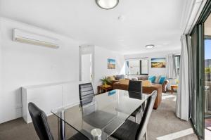 a living room with a glass table and chairs at Stylish Braddon Retreat 2Bedroom Free Parking & Pool in Braddon