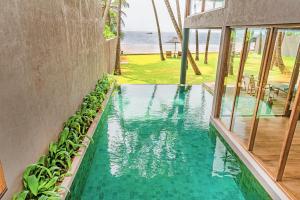 a swimming pool with a view of the ocean at Private Suite, The Coast Sri Lanka in Induruwa