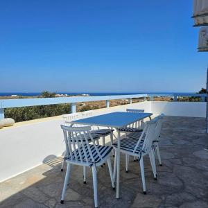 a blue table and chairs on a patio with the ocean at Blue and White View in Sarakíniko