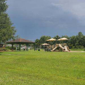a park with a playground with a slide and umbrellas at Family Getaway by Disney! in Kissimmee