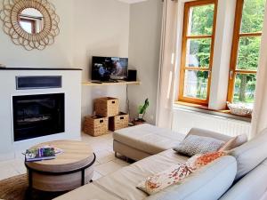 a living room with a couch and a fireplace at Maison indépendante en lisière de bois avec jardin, vélos, baby-foot et cheminée près de Paris. - FR-1-532-20 in Fontenelle